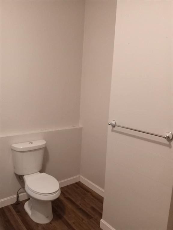 bathroom featuring toilet, wood finished floors, and baseboards