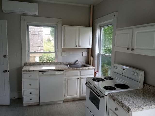 kitchen with a wall mounted AC, a sink, white appliances, white cabinets, and light countertops