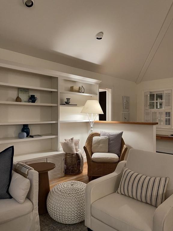 living area with lofted ceiling and wood finished floors