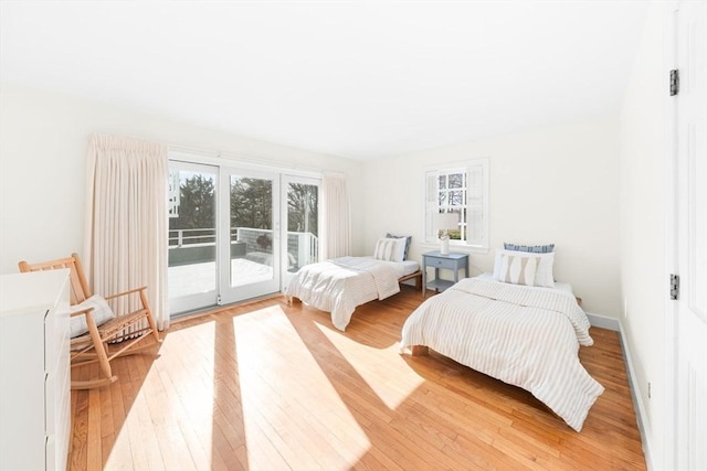 bedroom featuring light wood-type flooring, access to outside, and baseboards