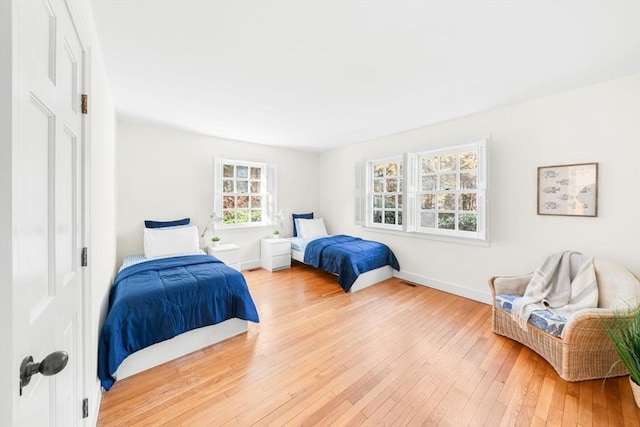 bedroom with light wood-style flooring and baseboards