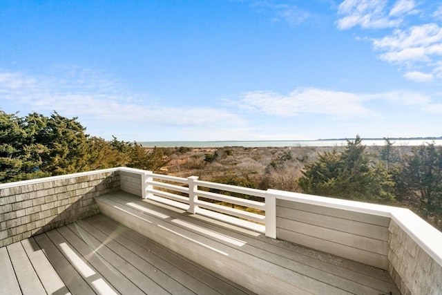 wooden terrace featuring a view of the beach and a water view