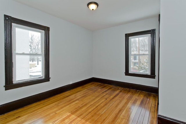 unfurnished room featuring wood-type flooring and baseboards