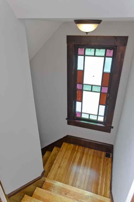 stairway with lofted ceiling and wood finished floors