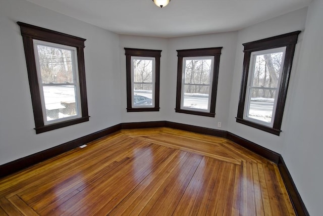 empty room featuring hardwood / wood-style flooring and baseboards