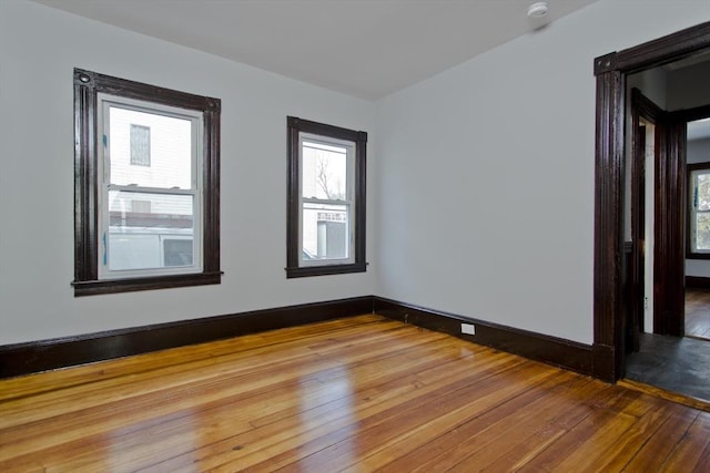 unfurnished room featuring hardwood / wood-style floors and baseboards