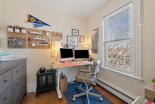 office area featuring baseboard heating, a healthy amount of sunlight, baseboards, and wood finished floors