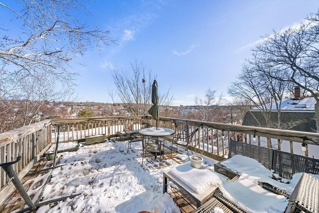 snow covered deck featuring outdoor dining area