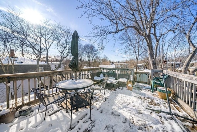 snow covered deck with outdoor dining area