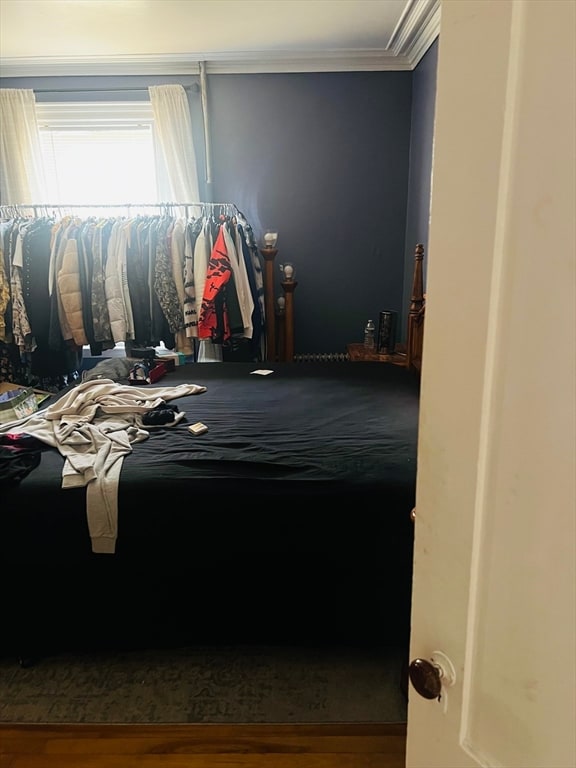 bedroom with crown molding and hardwood / wood-style flooring