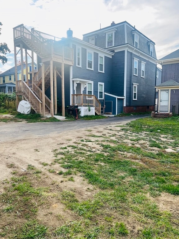 rear view of property featuring a wooden deck