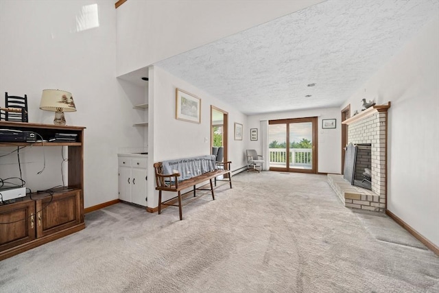 sitting room with a brick fireplace, carpet, baseboards, and a textured ceiling