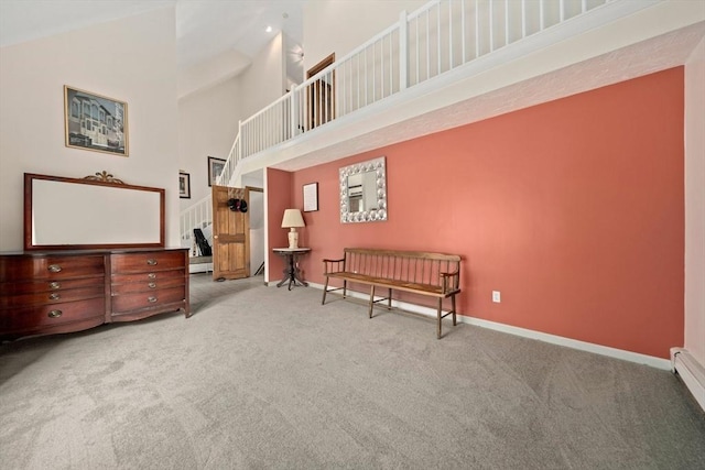 living area featuring baseboards, a towering ceiling, and carpet flooring