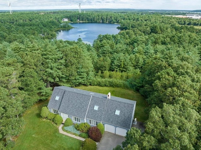 drone / aerial view with a wooded view and a water view