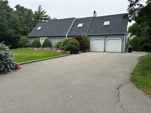 view of front of home with a garage and a front lawn