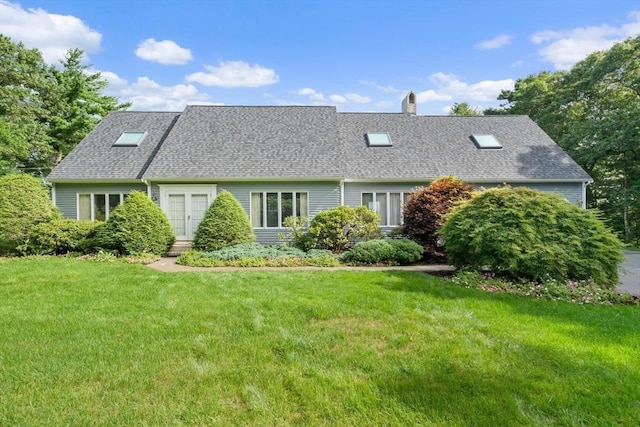 cape cod home with a front yard, a chimney, and a shingled roof