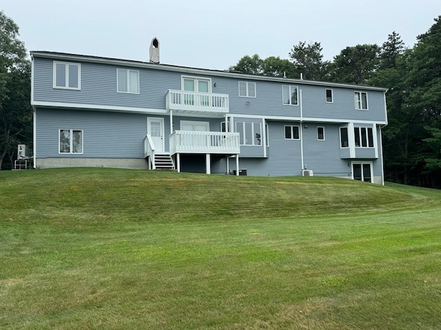 back of house with a deck and a yard