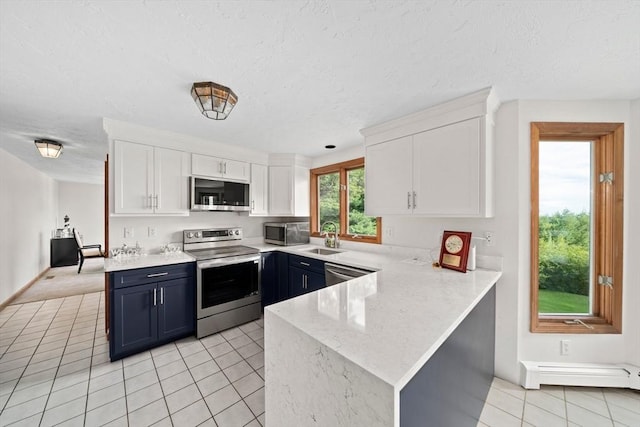 kitchen with a sink, a baseboard radiator, appliances with stainless steel finishes, and white cabinetry