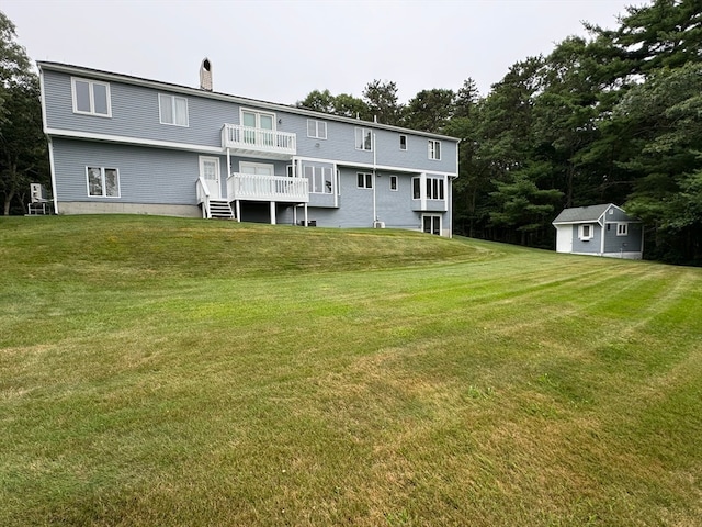 back of house featuring a storage shed and a yard