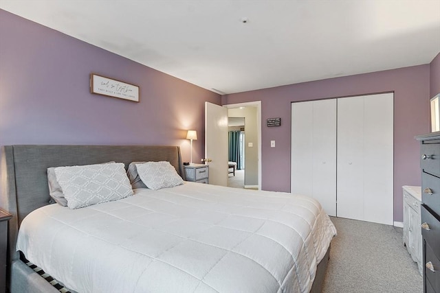 carpeted bedroom featuring a closet and baseboards