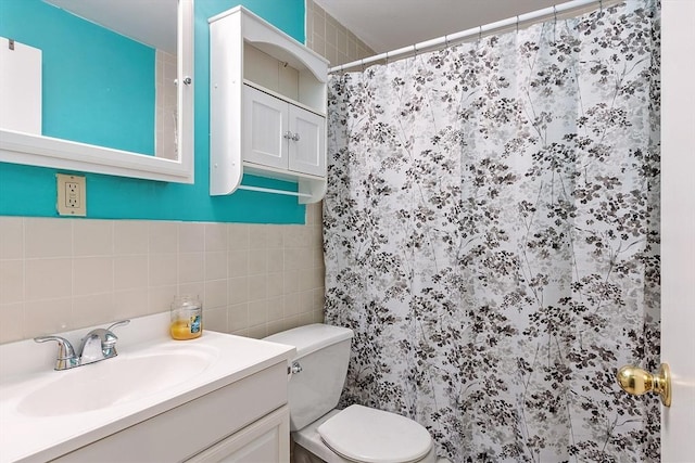 bathroom with curtained shower, vanity, tile walls, and toilet