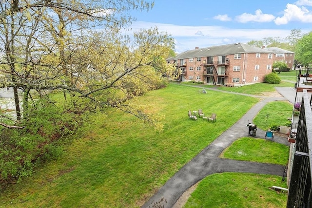 view of property's community with a lawn and driveway