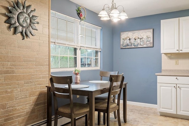 dining space with baseboards and a chandelier