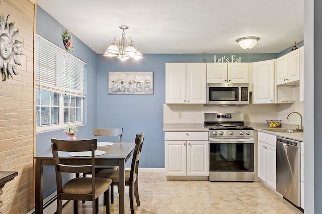 kitchen with white cabinets, light countertops, stainless steel appliances, and a sink