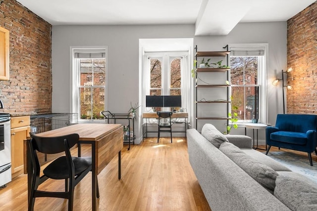 interior space featuring brick wall, plenty of natural light, and light wood-style flooring