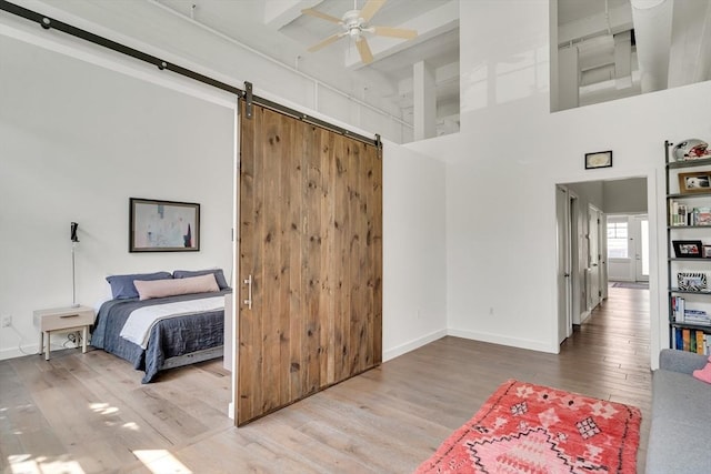 165 Chestnut Hill Ave Unit 3, Boston, MA 02135 - bedroom with wood finished floors, a barn door, a towering ceiling, and a ceiling fan