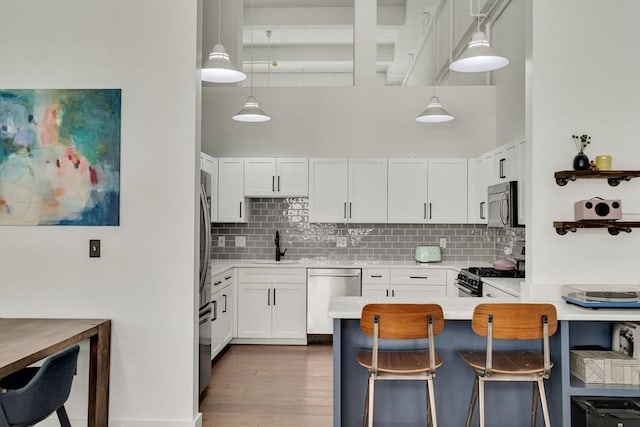 165 Chestnut Hill Ave Unit 3, Boston, MA 02135 - kitchen featuring appliances with stainless steel finishes, decorative backsplash, light countertops, white cabinets, and a high ceiling