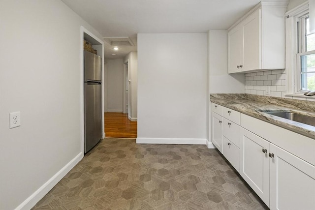 1652 Parker St, Springfield, MA 01128 - kitchen featuring freestanding refrigerator, a sink, baseboards, white cabinets, and light stone counters