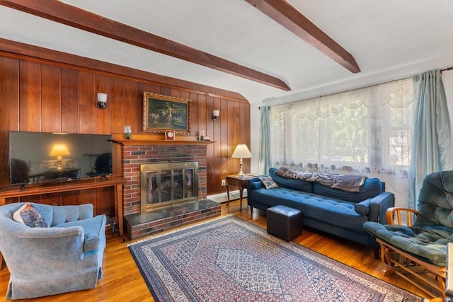 30 Stone St, Bellingham, MA 02019 - living area featuring light wood-type flooring, beam ceiling, a fireplace, and wooden walls