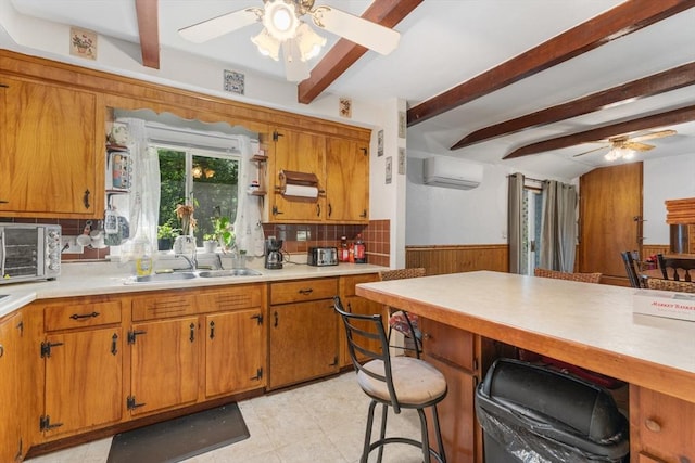 30 Stone St, Bellingham, MA 02019 - kitchen featuring ceiling fan, beam ceiling, light countertops, a wall mounted air conditioner, and a wainscoted wall