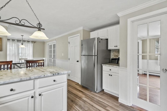 323 School St, Pembroke, MA 02359 - kitchen with freestanding refrigerator, white cabinetry, wood finished floors, a baseboard radiator, and light stone countertops