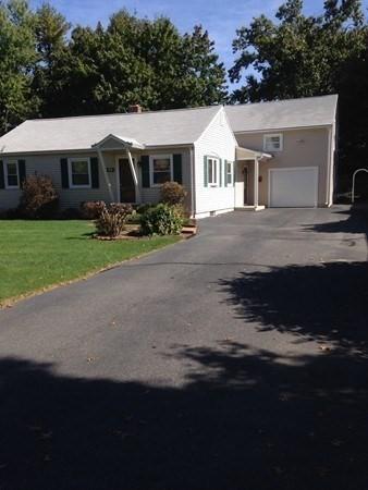 ranch-style home featuring a front yard, concrete driveway, and an attached garage