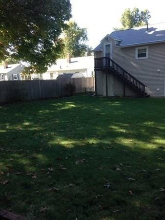 view of yard featuring stairway and fence