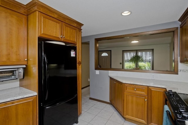 80 Vassar Rd, Agawam, MA 01030 - kitchen with freestanding refrigerator, stove, brown cabinets, light tile patterned floors, and recessed lighting