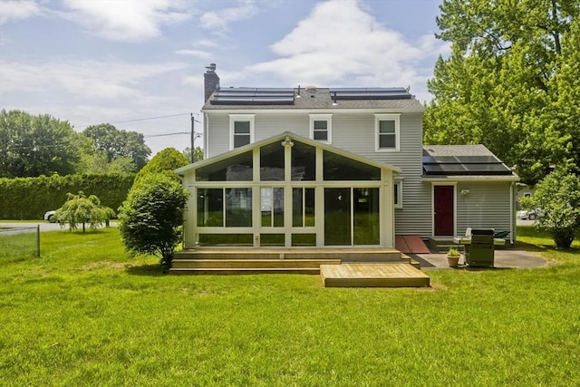80 Vassar Rd, Agawam, MA 01030 - rear view of house featuring a sunroom, solar panels, a yard, a chimney, and a patio area