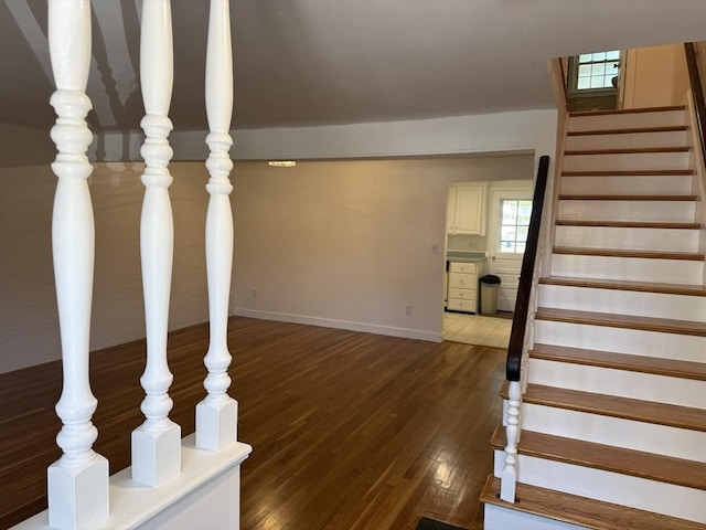 staircase with wood finished floors and baseboards