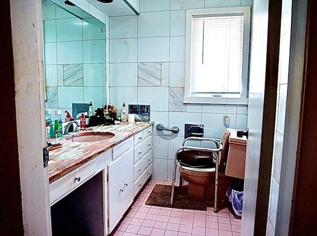 bathroom with tile patterned flooring, vanity, toilet, and tile walls