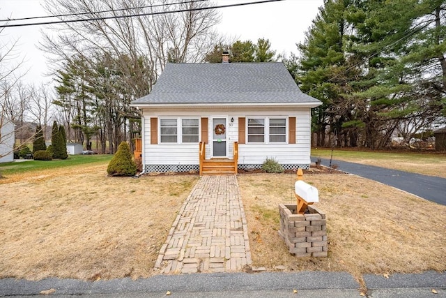 bungalow-style home featuring a front lawn