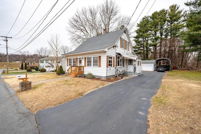 view of front of home featuring an outbuilding, a front lawn, a carport, and a garage