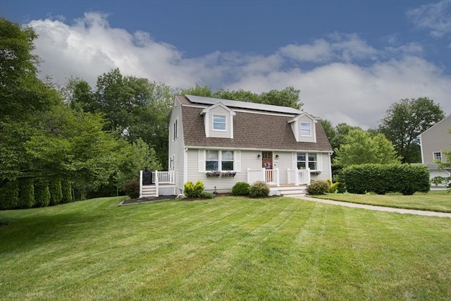 14 Robbins Rd, Ayer, MA 01432 - colonial inspired home featuring a front lawn, roof mounted solar panels, and a shingled roof