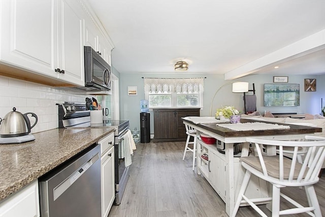 14 Robbins Rd, Ayer, MA 01432 - kitchen with stainless steel appliances, backsplash, white cabinetry, light wood-style flooring, and light stone countertops
