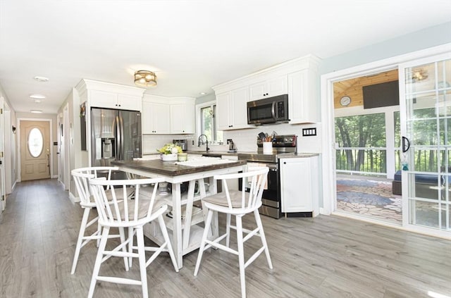 14 Robbins Rd, Ayer, MA 01432 - kitchen featuring appliances with stainless steel finishes, white cabinets, tasteful backsplash, and light wood-style floors