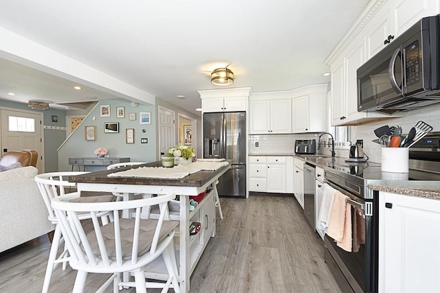 14 Robbins Rd, Ayer, MA 01432 - kitchen featuring appliances with stainless steel finishes, wood finished floors, decorative backsplash, white cabinetry, and recessed lighting
