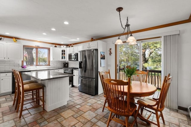 2 Lake Ave, Framingham, MA 01702 - kitchen with stainless steel appliances, crown molding, dark countertops, tasteful backsplash, and stone tile floors