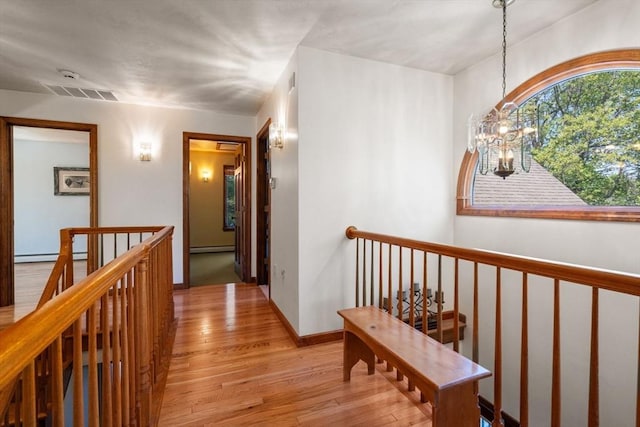 2 Lake Ave, Framingham, MA 01702 - corridor featuring an upstairs landing, light wood-type flooring, a chandelier, and baseboard heating