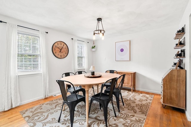 dining room featuring light wood-type flooring and a healthy amount of sunlight